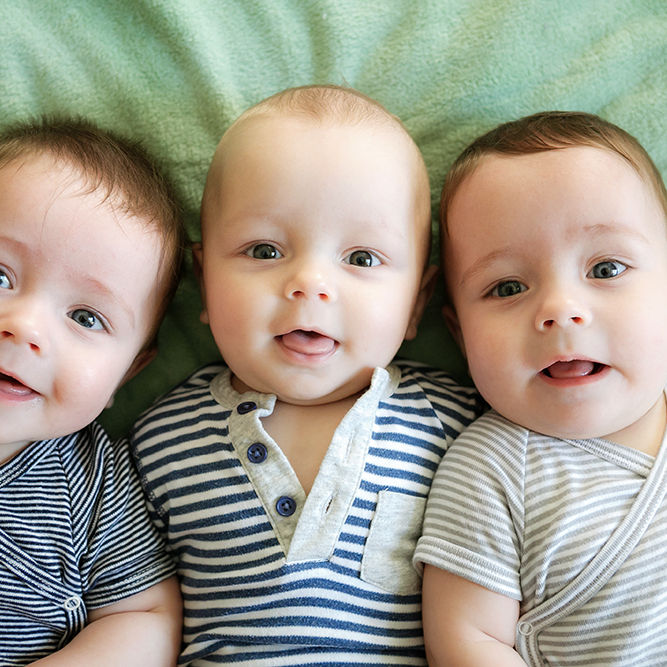 Portrait of newborn triplets are lying in the bed